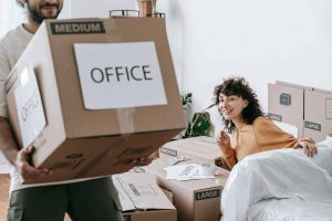 Man carring a box labeled office during an office relocation