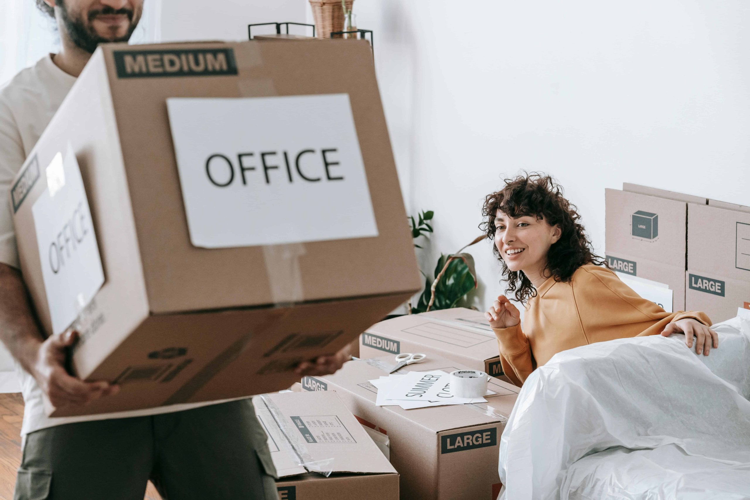 Man carring a box labeled office during an office relocation